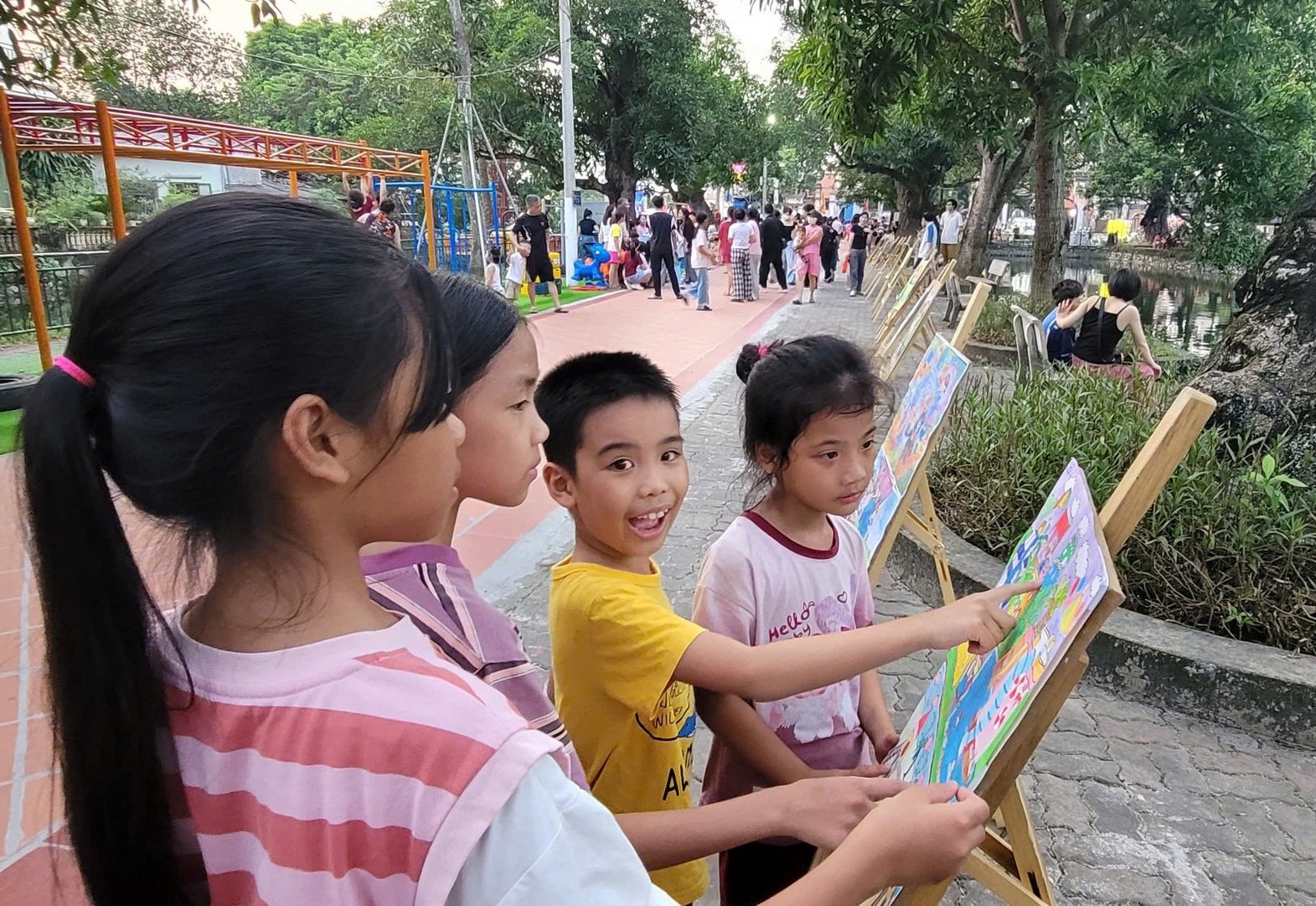 Các em nhỏ tỏ ra thích thú khi ngắm những tác phẩm từ cuộc thi vẽ tranh Sân chơi xanh cho tương lai em. Ảnh: Việt Hải.